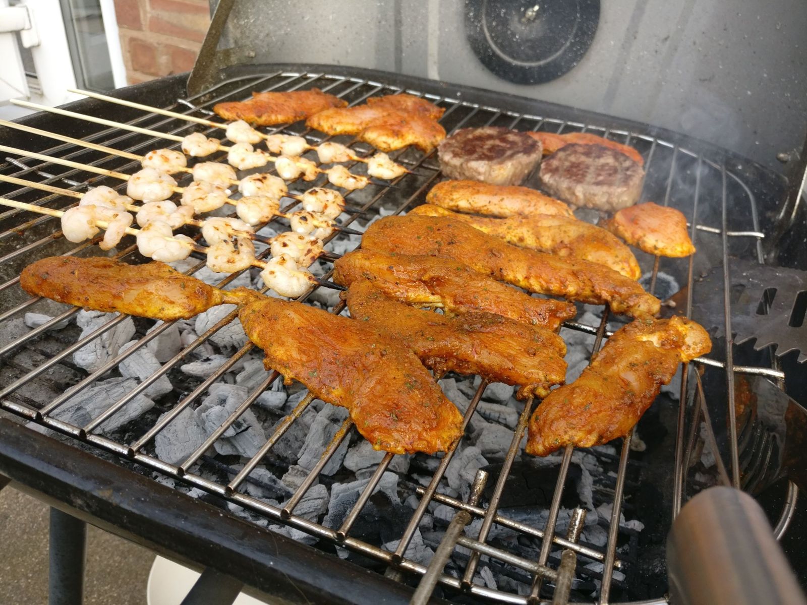 Prawn skewers on a grill over white-hot charcoal