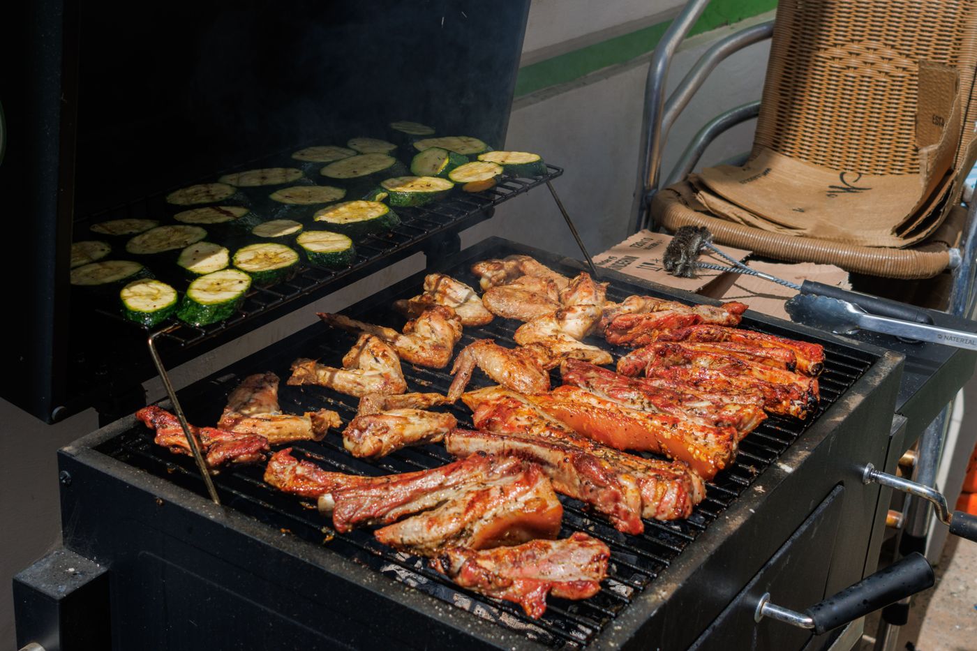 Meat and courgettes cooking on a charcoal grill