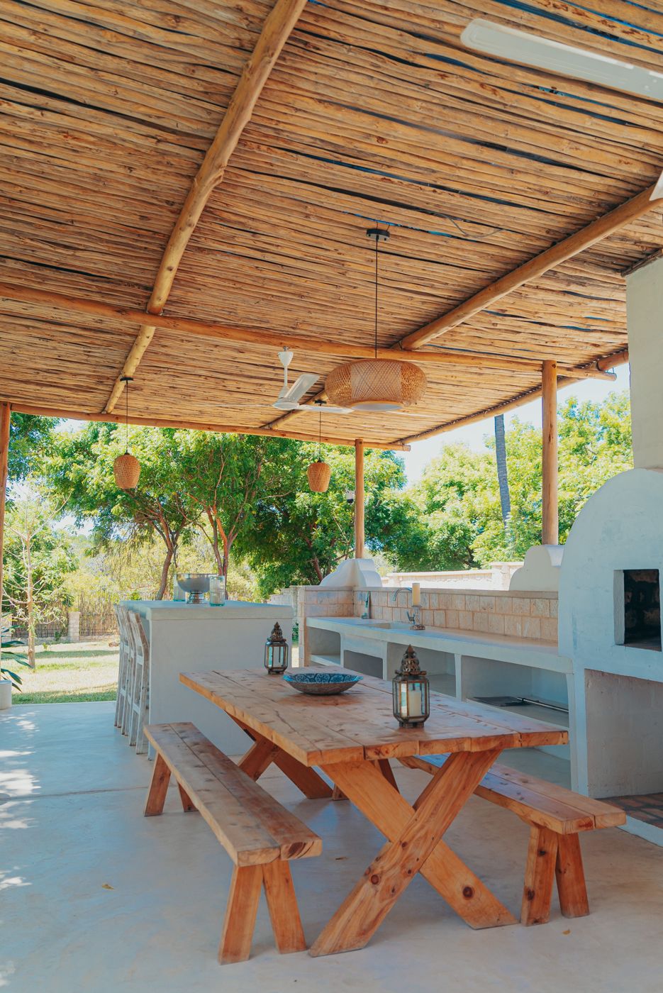 Covered outdoor kitchen and dining area on a paved patio