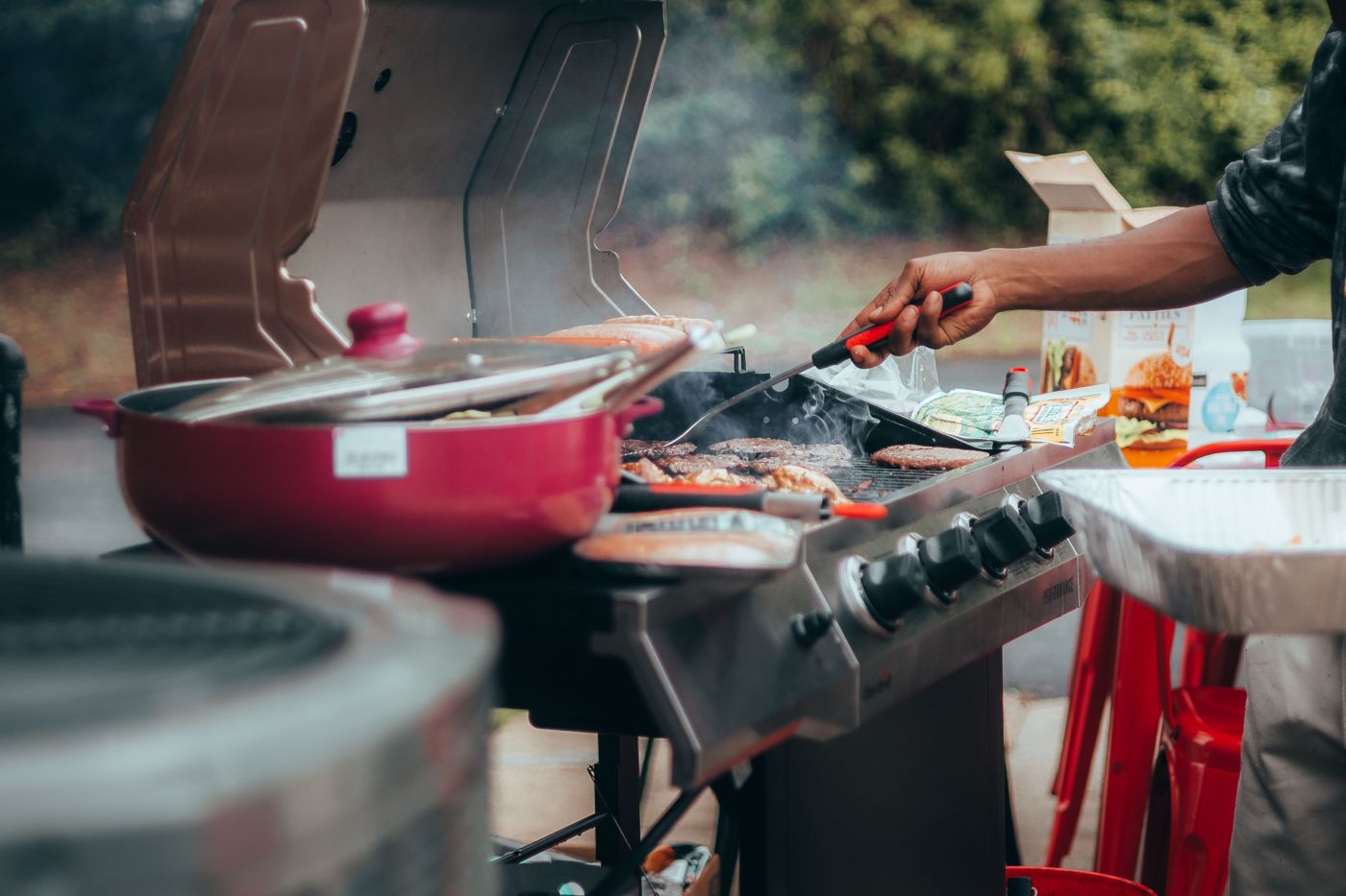 Burgers and sausages cooking on a gas BBQ
