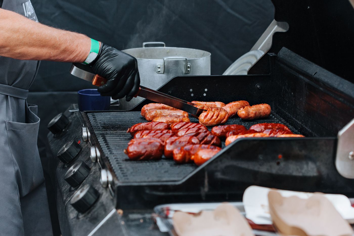 Sausages cooking on a gas BBQ grill