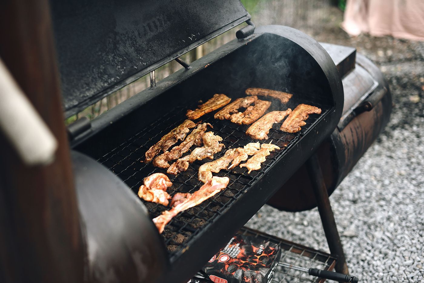 Meat cooking low and slow inside an offset smoker