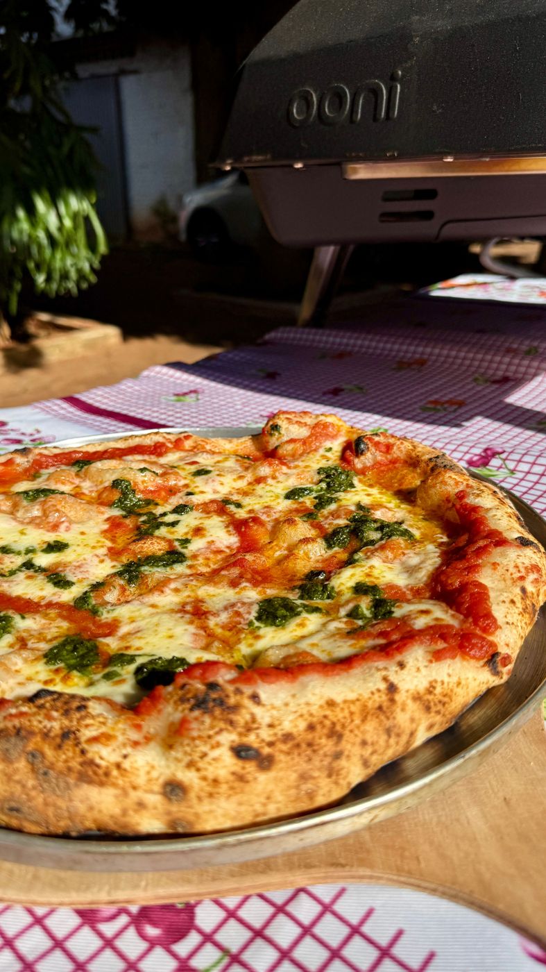 Margherita pizza in front of an Ooni oven